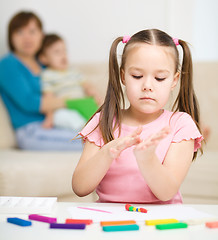 Image showing Little girl is playing with plasticine