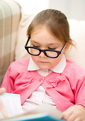 Image showing Little girl is reading a book