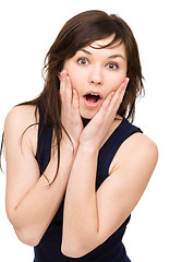 Image showing Woman is holding her face in astonishment