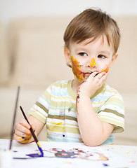 Image showing Little boy is playing with paints