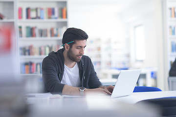 Image showing student in school library using laptop for research