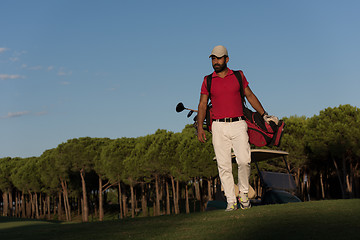 Image showing golfer  walking and carrying golf  bag