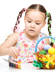 Image showing Little girl is painting eggs preparing for Easter