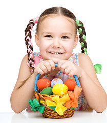 Image showing Little girl with basket full of colorful eggs