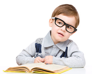 Image showing Little child play with book