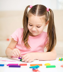 Image showing Little girl is playing with plasticine