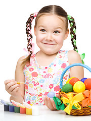 Image showing Little girl is painting eggs preparing for Easter