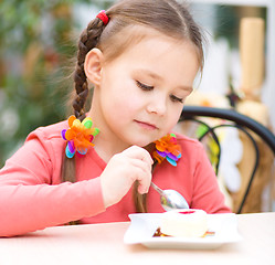 Image showing Little girl is eating cake in parlor