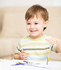 Image showing Little boy is playing with paints