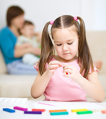 Image showing Little girl is playing with plasticine