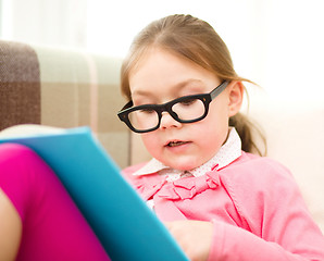 Image showing Little girl is reading a book