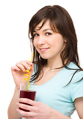 Image showing Young woman is drinking cherry juice