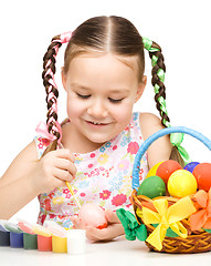 Image showing Little girl is painting eggs preparing for Easter