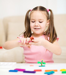 Image showing Little girl is playing with plasticine