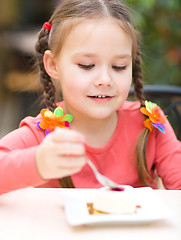 Image showing Little girl is eating cake in parlor