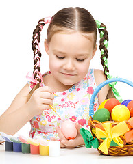 Image showing Little girl is painting eggs preparing for Easter