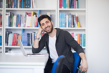 Image showing student in school library using laptop for research