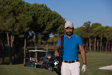 Image showing golfer  walking and carrying golf  bag