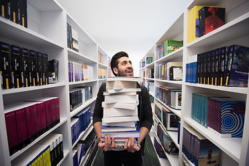 Image showing Student holding lot of books in school library