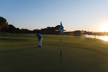 Image showing golfer hitting ball to hole