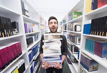 Image showing Student holding lot of books in school library