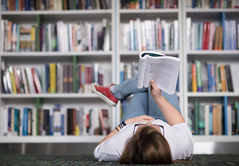 Image showing female student study in library, using tablet and searching for 