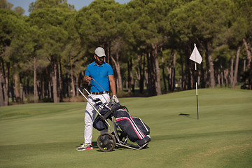 Image showing golf player walking with wheel bag