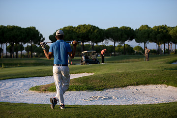 Image showing golfer from back at course looking to hole in distance