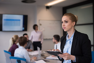 Image showing business woman working on tablet at meeting room