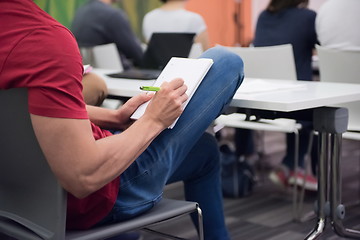 Image showing male student taking notes in classroom