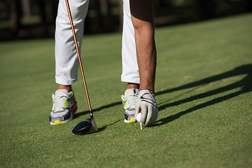 Image showing golf player placing ball on tee