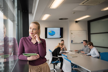 Image showing blonde businesswoman working on tablet at office