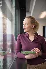 Image showing blonde businesswoman working on tablet at office