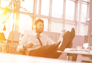 Image showing relaxed young businessman first at workplace at early morning