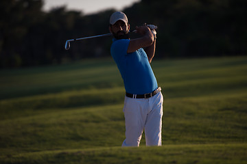 Image showing golfer hitting a sand bunker shot on sunset