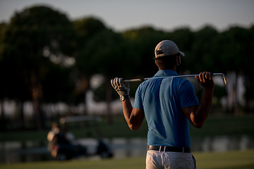 Image showing golfer from back at course looking to hole in distance