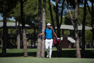 Image showing golf player walking and carrying bag