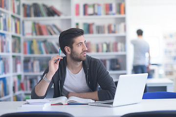 Image showing student in school library using laptop for research