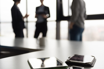 Image showing close up of tablet, business people on meeting in background