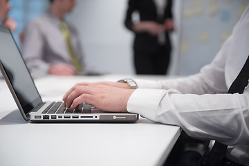 Image showing hands typing on laptop at meeting