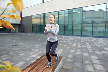 Image showing woman making step exercise on city street bench