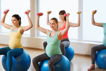 Image showing happy pregnant women exercising on fitball in gym