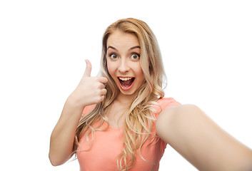 Image showing happy woman taking selfie and showing thumbs up