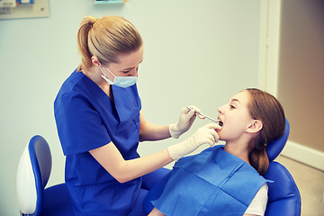 Image showing female dentist checking patient girl teeth