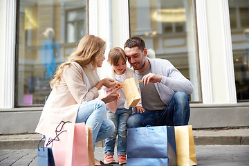 Image showing happy family with child and shopping bags in city