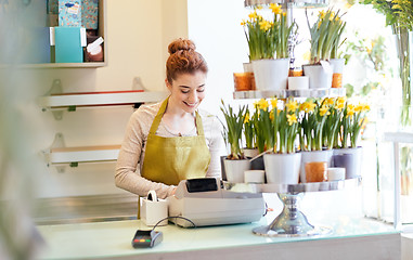 Image showing florist woman at flower shop cashbox on counter