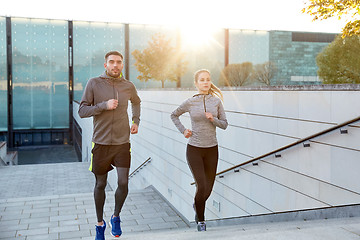 Image showing happy couple running upstairs on city stairs