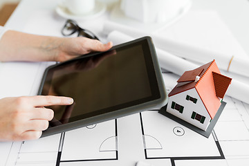 Image showing close up of hand with blueprint and tablet pc