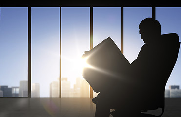 Image showing silhouette of businessman reading documents