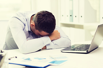 Image showing businessman with laptop and papers in office